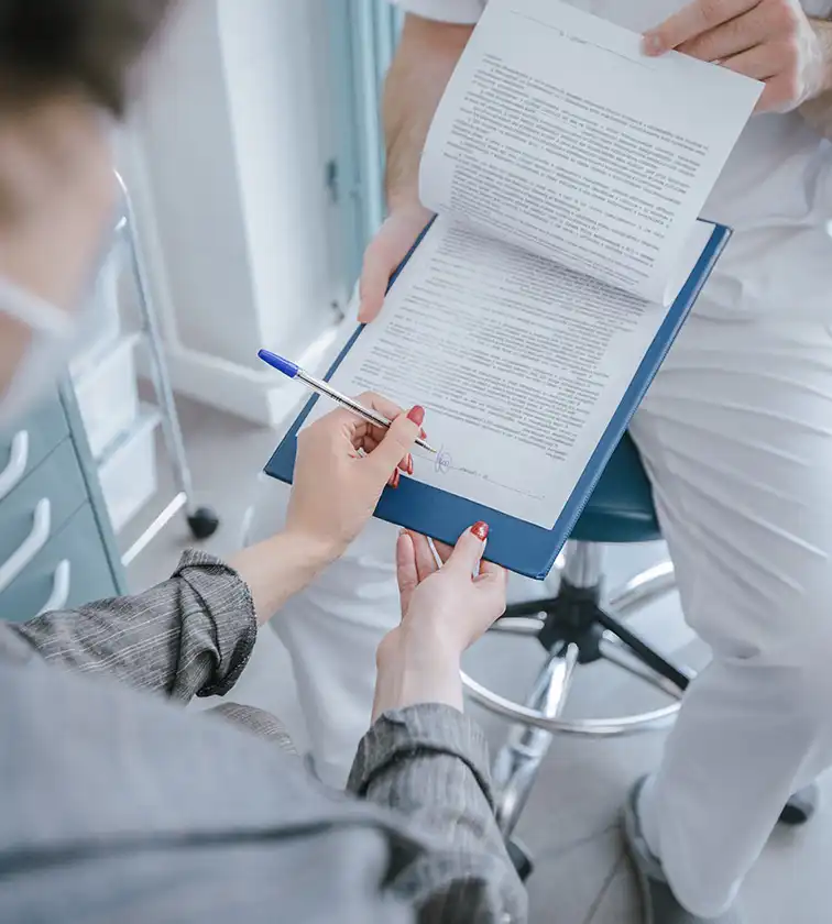 Angehörige unterzeichnet Unterlagen zur Kostenübernahme der Intensivpflege – erbu klärt alles mit der Krankenkasse.
