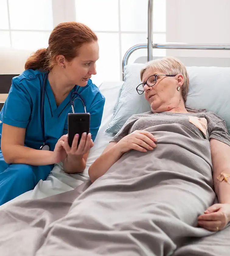 Pflegefachkraft bespricht Pflegeplan mit Patientin – 1:1-Betreuung bei häuslicher Intensivpflege Hamm.